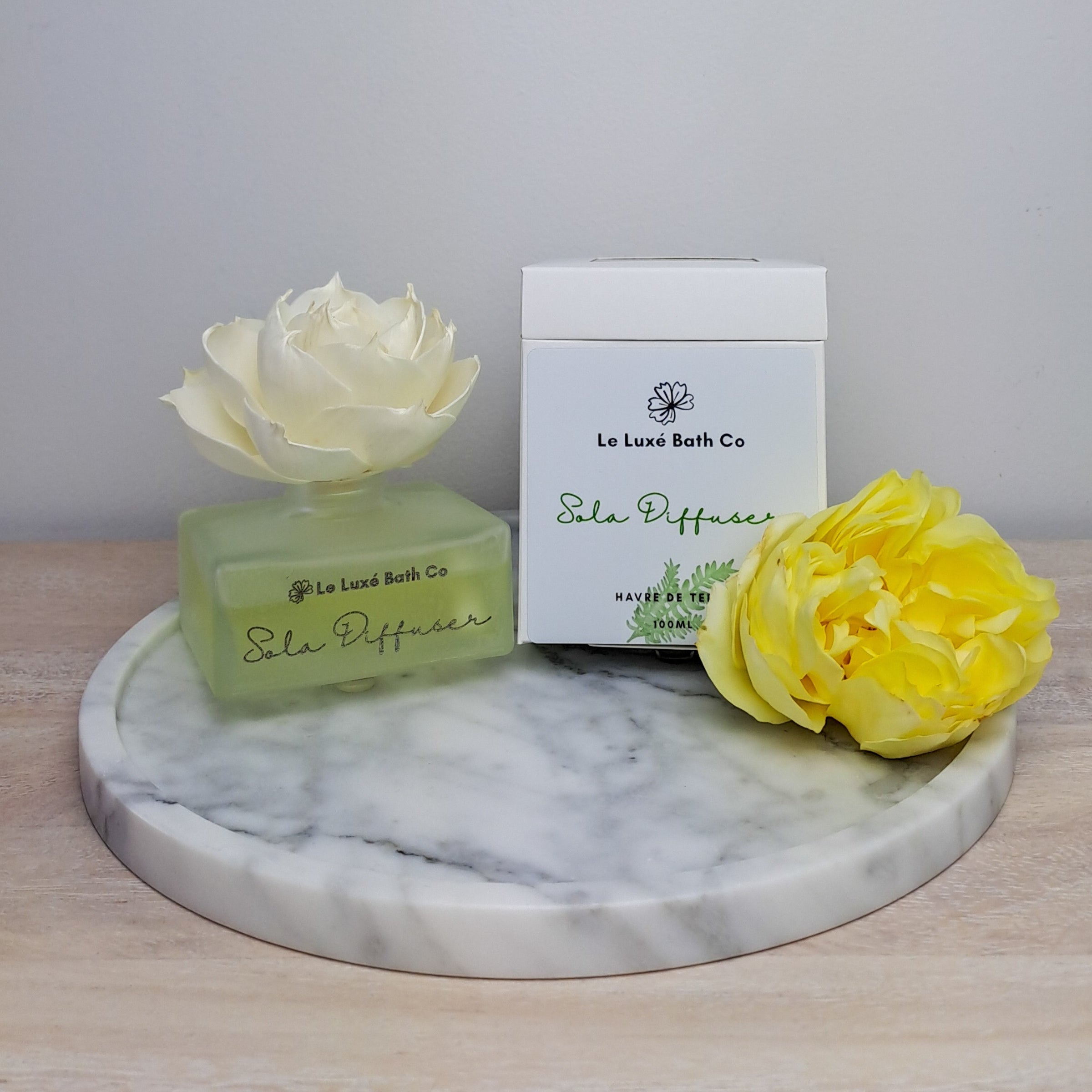 Le Luxé Bath Co Sola Flower Fragrance Diffuser with fresh rose on marble and wood surface